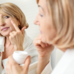 Woman putting cream on her face