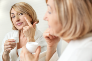 Woman putting cream on her face